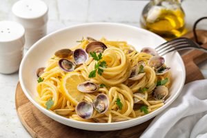Italian pasta spaghetti with clams and lemon or Spaghetti alle vongole verace, cooked with oil, white wine, garlic, parsley.